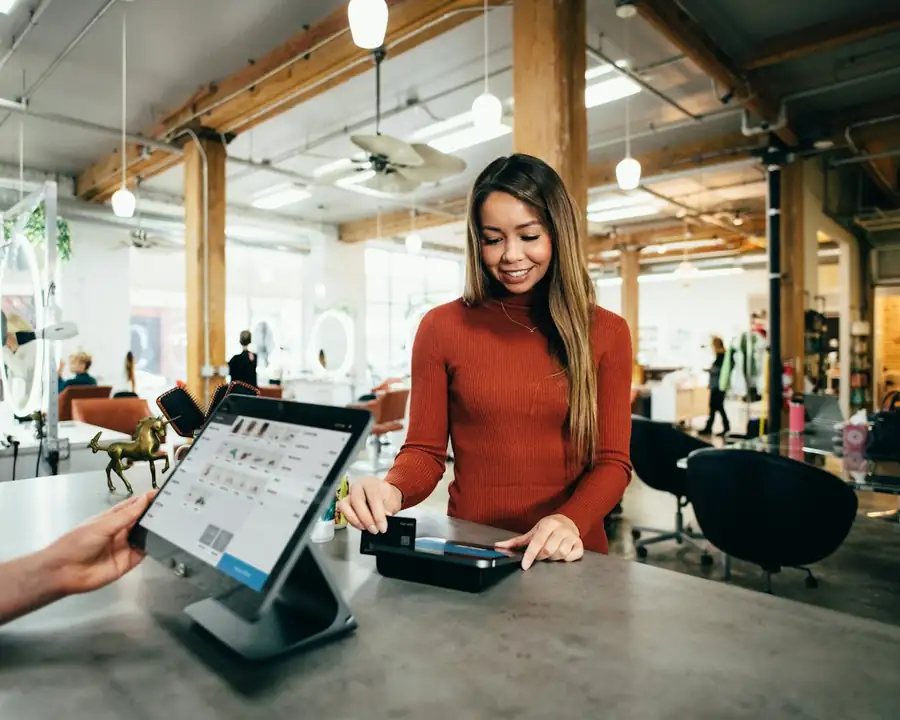 A small-business owner taking a card payment at the counter